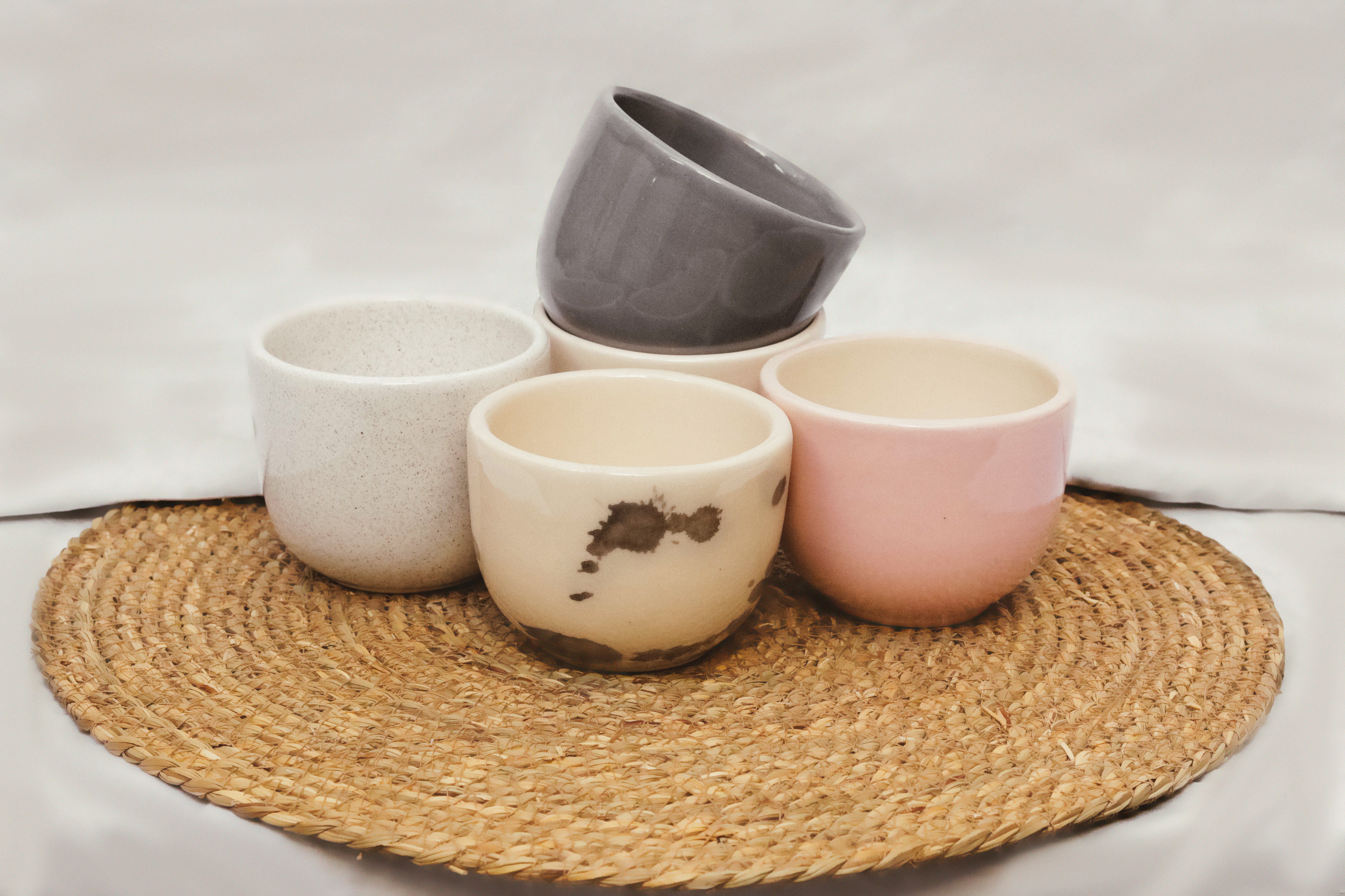 Cuatro piezas de cerámica artesanal en tonos pastel